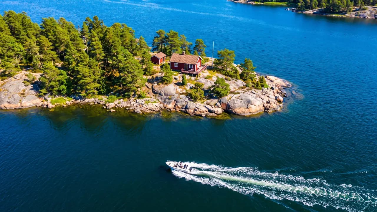 Flygbild över skärgården med röd stuga